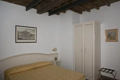 a white bedroom with a bed and a cabinet at Best Suites Pantheon in Rome