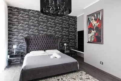 a bedroom with a bed and a wall covered in writing at Town House Roma in Rome