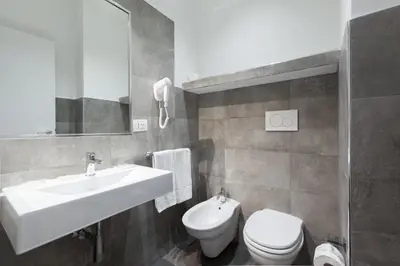 a bathroom with a sink and a toilet and a mirror at Town House Roma in Rome