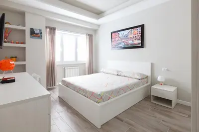 a white bedroom with a bed and a desk at Un Passino da San Pietro Casa in Rome