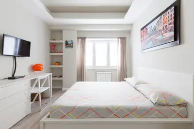 a white bedroom with a bed and a tv at Un Passino da San Pietro Casa in Rome