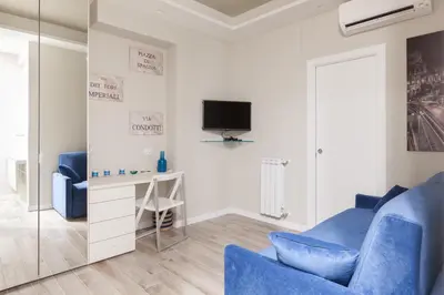 a living room with a blue couch and a tv at Un Passino da San Pietro Casa in Rome