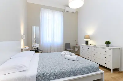 a white bedroom with a bed and a dresser at Stazione Vaticana 5 Apartment in Rome