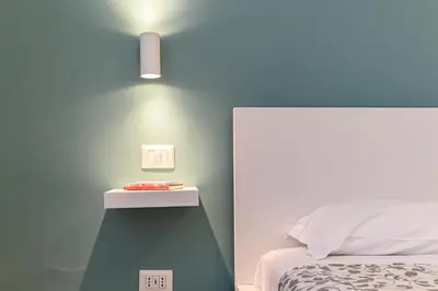 a bedroom with a bed and a light on the wall at Stazione Vaticana 5 Apartment in Rome