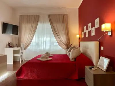 a bedroom with a red bed with a stuffed animal on it at Le Coq Suites in Rome