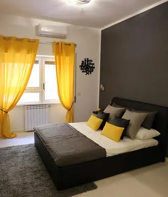 a bedroom with a large bed with yellow curtains at Le Coq Suites in Rome