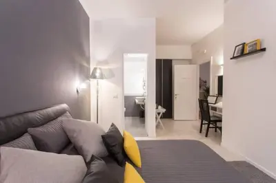 a living room with a couch and a dining room at Le Coq Suites in Rome