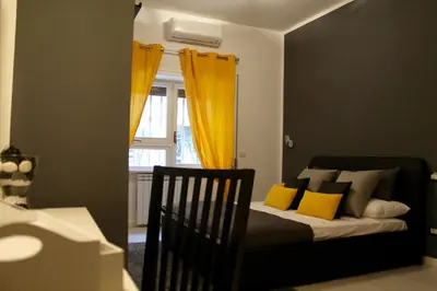 a bedroom with a bed with yellow curtains and a window at Le Coq Suites in Rome