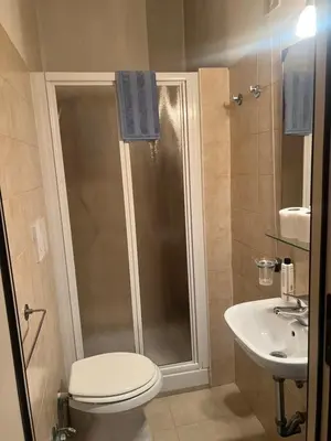 a bathroom with a shower and a toilet and a sink at Ines Downtown B&B in Rome