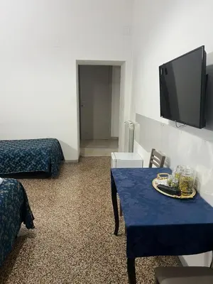 a room with a blue table and a tv at Ines Downtown B&B in Rome