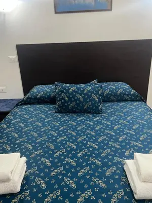 a bed with a blue bedspread and pillows on it at Ines Downtown B&B in Rome