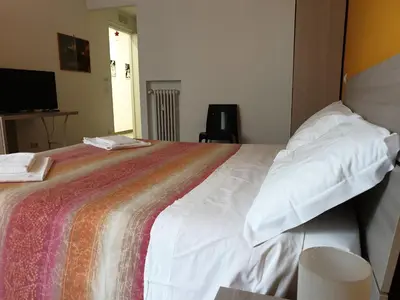 a bedroom with a large white bed with a colorful blanket at Holidays in Rome - Guesthouse in Rome