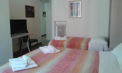 a hotel room with two beds and a television at Holidays in Rome - Guesthouse in Rome