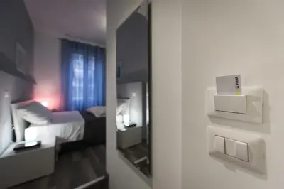 a room with a mirror and a bedroom with a bed at Holidays in Rome - Guesthouse in Rome