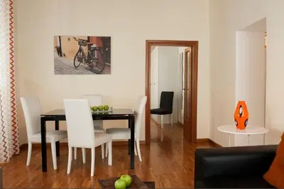 a dining room with a black table and white chairs at FL Apartments Charming Flat in the heart of Trastevere in Rome