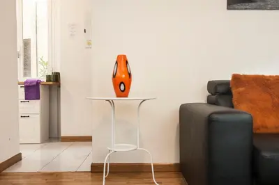 an orange vase on a table next to a couch at FL Apartments Charming Flat in the heart of Trastevere in Rome