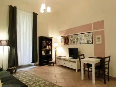 a living room with a table and a desk with a television at Magenta Collection Del Grande in Rome