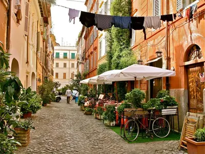 a street with a market with a bicycle and umbrellas at Magenta Collection Del Grande in Rome