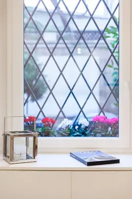 a window with flowers and a book on a counter at Wake At Rome in Rome