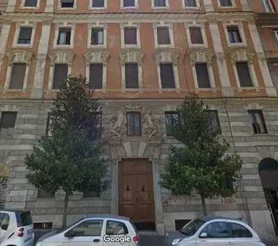 two cars parked in front of a building with a door at Wake At Rome in Rome