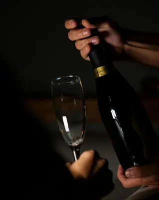 a person pouring a bottle of wine into a glass at New Design St.Peter in Rome