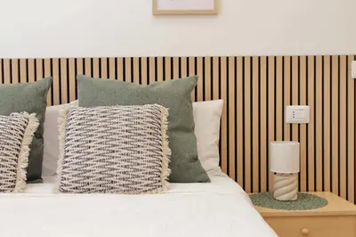 a bed with green and white pillows at Nancy Bleisure Suite by DomusDimore in Rome