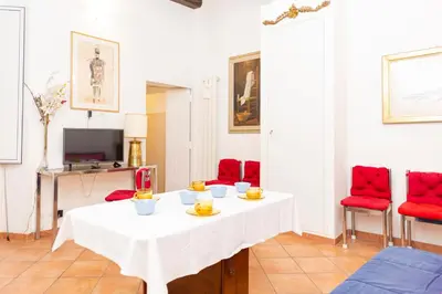 a living room with a white table and red chairs at Piazza Farnese in Rome