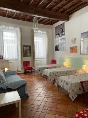 a room with several beds and chairs and windows at Piazza Farnese in Rome