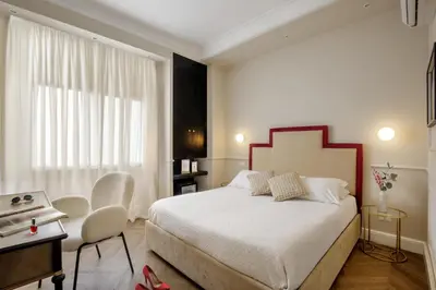 a bedroom with a bed and a table and chairs at Daplace - La Locanda di Piazza del Popolo in Rome