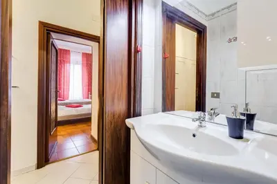 a white bathroom with a sink and a mirror at Casa Vacanza Home Sweet Home di Fatha in Rome