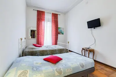 a bedroom with two beds and a tv on the wall at Casa Vacanza Home Sweet Home di Fatha in Rome
