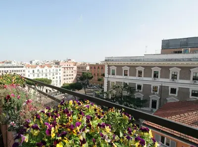 a view of a city from a balcony with flowers at Le case di Andrea - Roof Suite Rome in Rome