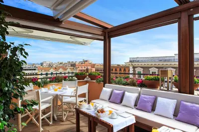 a balcony with tables and chairs and a view of the city at Le case di Andrea - Roof Suite Rome in Rome