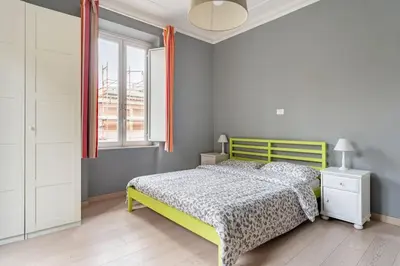 a bedroom with a yellow bed and a window at Walking to Trastevere di Marialaura Aragno in Rome