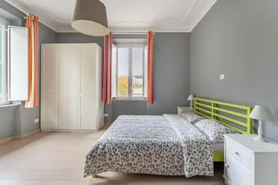 a bedroom with a bed and two windows at Walking to Trastevere di Marialaura Aragno in Rome