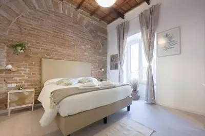 a brick walled bedroom with a large bed in a room at White Ostilia Apartments in Rome