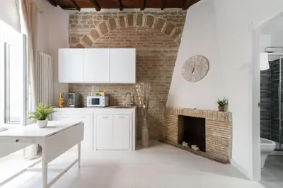 a kitchen with a brick wall and a fireplace at White Ostilia Apartments in Rome