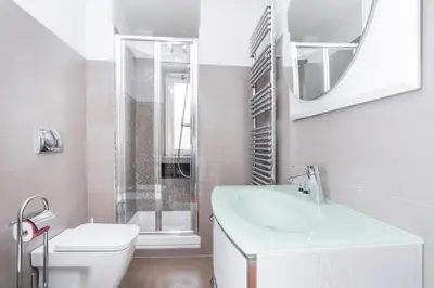 a white bathroom with a sink and a toilet at Enjoy the Sunset on Your Vatican Terrace in Rome