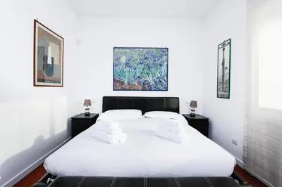 a bedroom with a large white bed with two night stands at Enjoy the Sunset on Your Vatican Terrace in Rome