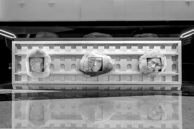 a display case with three heads of heads on a shelf at Gioberti Art Hotel in Rome