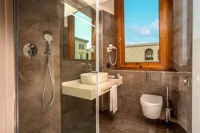 a bathroom with a sink and a shower with a mirror at Gioberti Art Hotel in Rome
