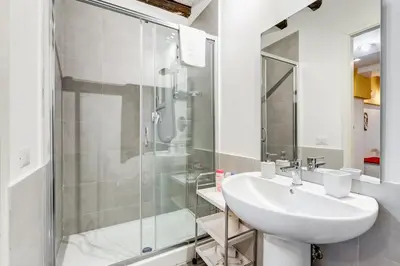 a white bathroom with a sink and a shower at Trastevere Suite Just Renewed in Rome