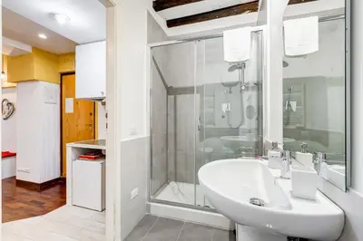 a white bathroom with a shower and a sink at Trastevere Suite Just Renewed in Rome