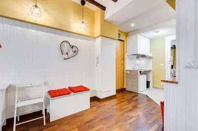 a kitchen with white cabinets and orange cushions at Trastevere Suite Just Renewed in Rome