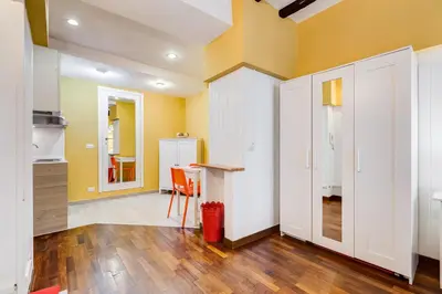 a kitchen with yellow walls and a table and orange chairs at Trastevere Suite Just Renewed in Rome