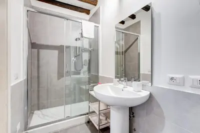 a white bathroom with a sink and a shower at Trastevere Suite Just Renewed in Rome