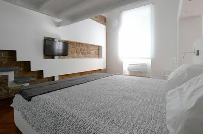 a bedroom with a bed and a tv on a wall at Castelfidardo Apartment in Rome