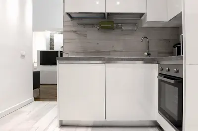 a kitchen with white cabinets and a sink at Castelfidardo Apartment in Rome
