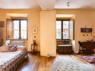 a bedroom with two beds and a table and windows at Apartment 'Colo' by Interhome in Rome