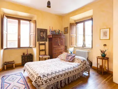 a bedroom with a bed and a dresser and windows at Apartment 'Colo' by Interhome in Rome